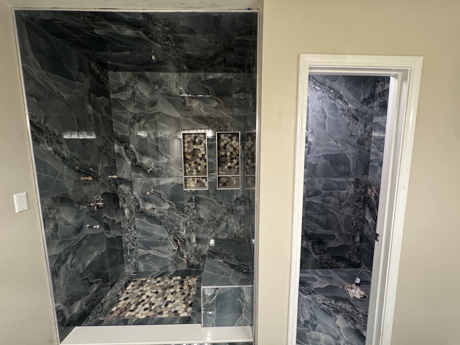 Terrones Ceramic Tile shower installation with dark stone-look tile and mosaic niches