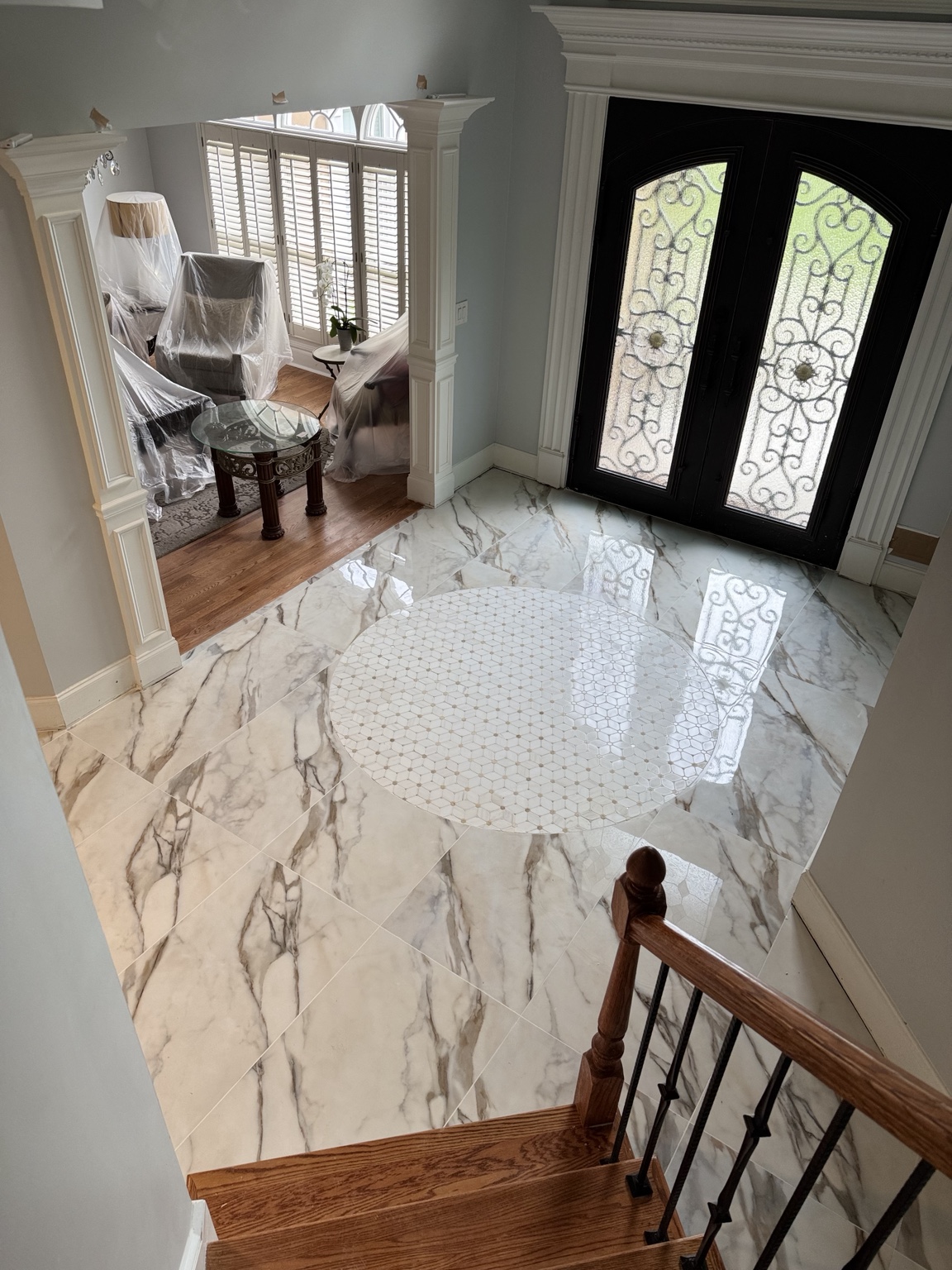 Marble-look entryway tile with a circular mosaic feature