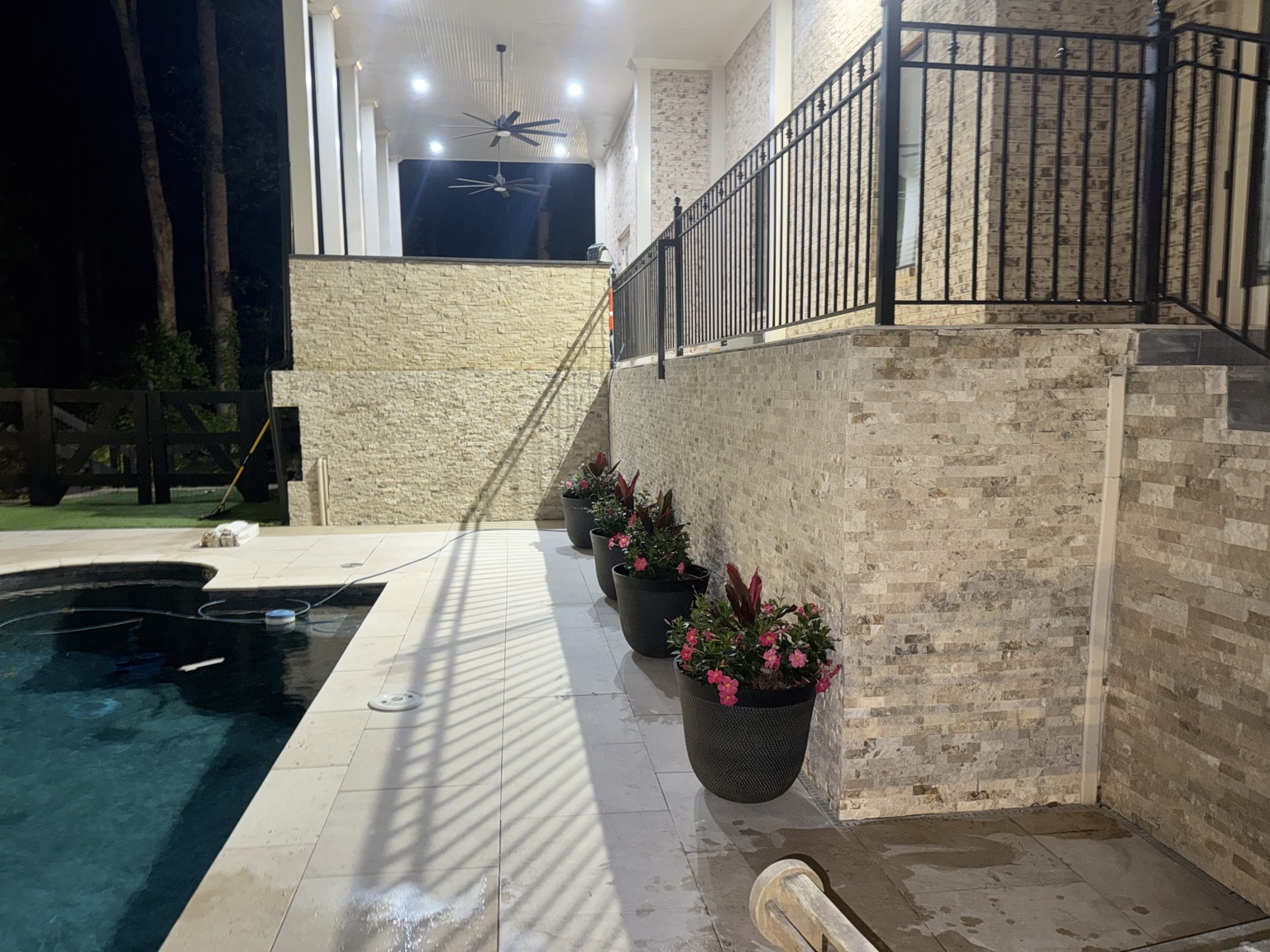 Outdoor patio and poolside area with stone-look wall cladding